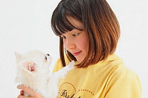 Portrait of young girl, holding a white Chihuahua puppy