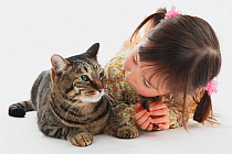 Portrait of young girl sitting with short-haired tabby cat