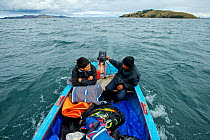 Reseachers and snorkling equipment in a boat on Lake Titicaca, Bolivia, October 2013. Model Released.