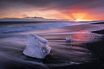 Chunks of ice on Diamond Beach at sunset, a strip of black sand belonging to the greater Breioamerkursandur glacial plain, located by Jokulsarlon glacier lagoon, south coast of Iceland. February, 2024...