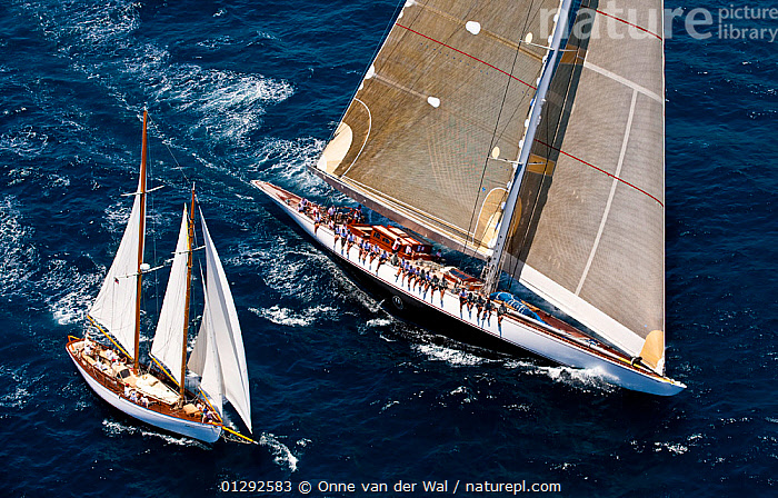 Stock photo of Smaller yacht flanking J Class