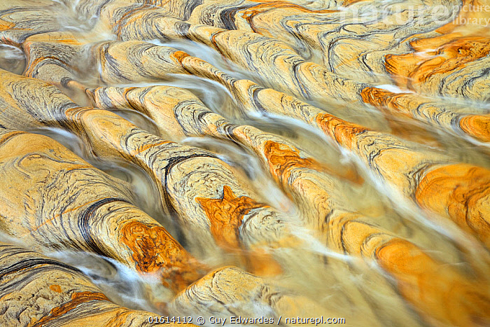 Stock photo of Water flowing over weathered rock with natural patterns ...
