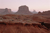 Buttes and sand dunes at dusk, Monument Valley Navajo Tribal Park, Arizona
