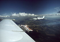 Cloud seeding equipment on wing of plane viewed through window flying over North Dakota