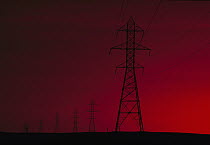 Transmission towers and wires against a red sky, South Dakota