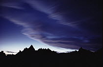Clouds rolling across mountain range at twilight, Badlands National Park, South Dakota