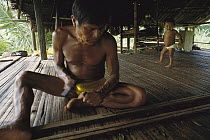 Embera Choco Indian making a blowgun for hunting with poisoned darts, Colombia