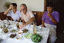 Herpetologist Ted Papenfuss tries snake meat at a specialty restaurant, Hanoi, Vietnam