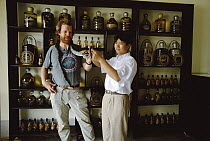 Mark Moffett and store proprietor with live snake in specialty store selling snake wine, Hanoi, Vietnam