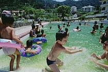 Tourists from cities come to Tam Dao for weekends and holidays, children playing in pool near the border of Tam Dao National Park, Vietnam