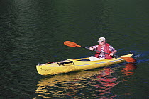 Kayaker padling on calm sea, southeast Alaska