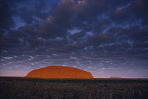 Ayers Rock at sunset with cloudy sky, Uluru-Kata Tjuta National Park, Northern Territory, Australia