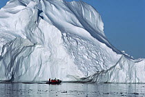 Tourists in an inflatable zodiac boat approaching an iceberg, Antarctica