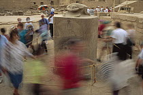 Tourists circle sacred scarab at Karnak for traditional good luck, Luxor, Egypt