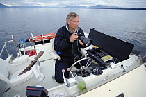 Humpback Whale (Megaptera novaeangliae) researcher Jim Darling photographing whales for identification, southeast Alaska