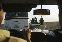 Researchers' military escort gets ice from bus while maintaining high speed, near the Afghan border, Iran
