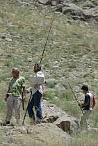 Researchers Bob Macey, Ted Papenfuss and Hadi Fahini with fishing poles hunting for specimens in desert, Deh Bala, Iran