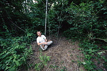 Photographer, Mark Moffett on assignment, National Geographic May 1999, shown sitting near Triplaris ant tree, Peru