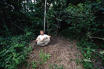 Photographer, Mark Moffett on assignment, National Geographic May 1999, shown sitting near Triplaris Ant tree, Peru
