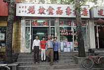 Photographer, Mark Moffett with cup of ant tea, outside ant medicinal shop, Beijing