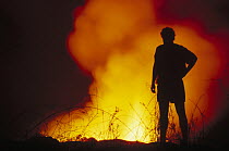 Galapagos native Gil De Roy admires nocturnal display of fountain lava, Cape Hammond, Fernandina Island, Galapagos Islands, Ecuador