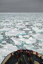 Passengers on bow watching the Russian icebreaker Capitan Klhebnikov forging through sea ice, Ross Sea, Antarctica