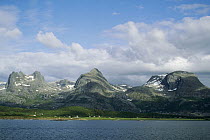 Norwegian fjord, small farming community along narrow coastal waterway, Seven Sisters mountain range of glacier sculpted granite, Norway