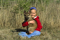 German Shepherd (Canis familiaris) puppy held by a young girl