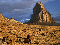 Shiprock, the basalt core of an extinct volcano, tuff-breccia ejected boulders in foreground, New Mexico