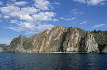 Red rocks cliffs along shoreline, Lake Baikal, Russia