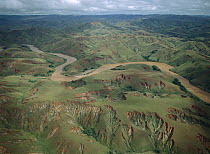 Deforested and deeply eroded hills alongside silted river, Betsiboka River, Madagascar