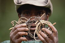 Vatari, anti-poaching patrol member, showing animal snare, Parc National des Volcans, Rwanda