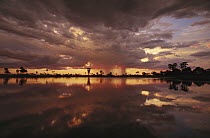 Sunset and storm clouds over watering hole in Kwando River flood plain, Linyanti Swamp, Okavango Delta, Botswana