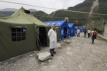 Doctor standing outside temporary shelters after the May 12, 2008 earthquake and landslides, CCRCGP, Wolong, China