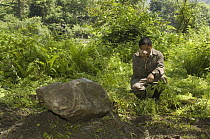 Giant Panda (Ailuropoda melanoleuca) keeper, He Changgui tearfully praying beside Mao Mao's tombstone after the May 12, 2008 earthquake and landslides, CCRCGP, Wolong, China
