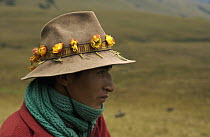 Chagra cowboy portrait with roses in his hat band, on an overnight ride at a hacienda to herd cattle, Andes Mountains, Ecuador