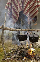 Chagra cowboys with cooking in camp at a hacienda during the annual overnight cattle round-up, Andes Mountains, Ecuador