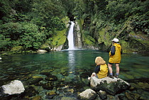 Two hikers relaxing at Giants Gates Falls, Milford Track, Fjordland National Park, New Zealand