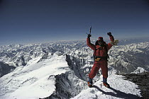 Climber on the summit of Pik Kommunizma at 7,500 meters elevation, highest mountain in the Pamirs, a mountain range in Tajikistan, central Asia