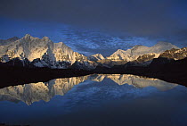 Panoramic view from Mt Makalu, elevation 8,462 meters, to Mt Everest, elevation 8,850 meters, at dawn, reflected in small lake, Khama Valley, Kharta region, Tibet