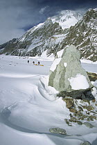 Three climbers pulling sleds under Broad Peak, Godwin Austen Glacier, Karakoram Mountains, Pakistan