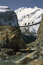 Trekkers cross a swing bridge over the Braldu River en route to Baltoro Glacier, Karakoram Mountains, Pakistan