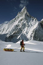 Skier passing icy Mitre Peak, Baltoro Glacier, Karakoram Mountains, Pakistan