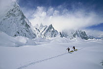 Two skiers pulling sleds under Mitre Peak, Godwin Austen Glacier, Karakoram Mountains, Pakistan