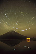 Star trails around the south celestial pole in the evening sky over the Pouakai Range, Egmont National Park, New Zealand