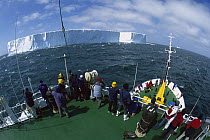 Tourists viewing large tabular icebergs from the deck of a boat, Southern Ocean, Antarctica