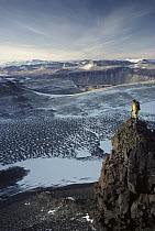 Man standing on a rock overlooking the Olympus Range, dry valleys, Antarctica