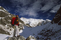 Trekker beneath Kangchenjunga, Talung face from Dzong Ri, 8585 meters, most easterly of the world's fourteen 8000 metre peaks, Sikkim Himalaya, India
