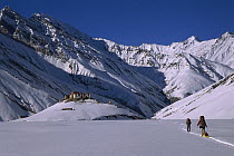 Rangdum Gompa monastery in winter with skiers approaching from Panzi La, Kindom of Zanskar, India