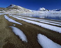 Snow patterns on shoreline ridges beside the partly frozen Blue Lake, Mount Tongariro, Tongariro National Park, New Zealand